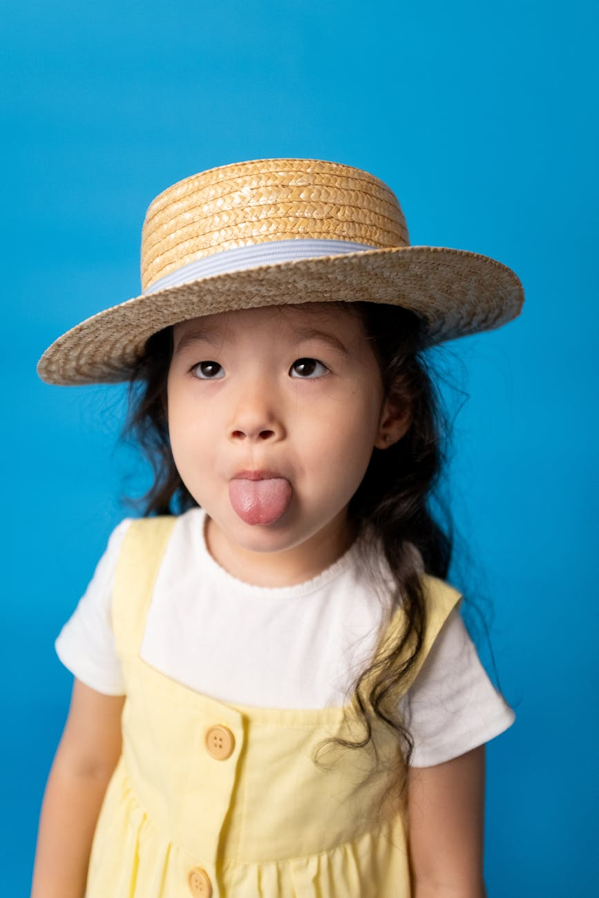 girl in yellow shirt wearing brown hat